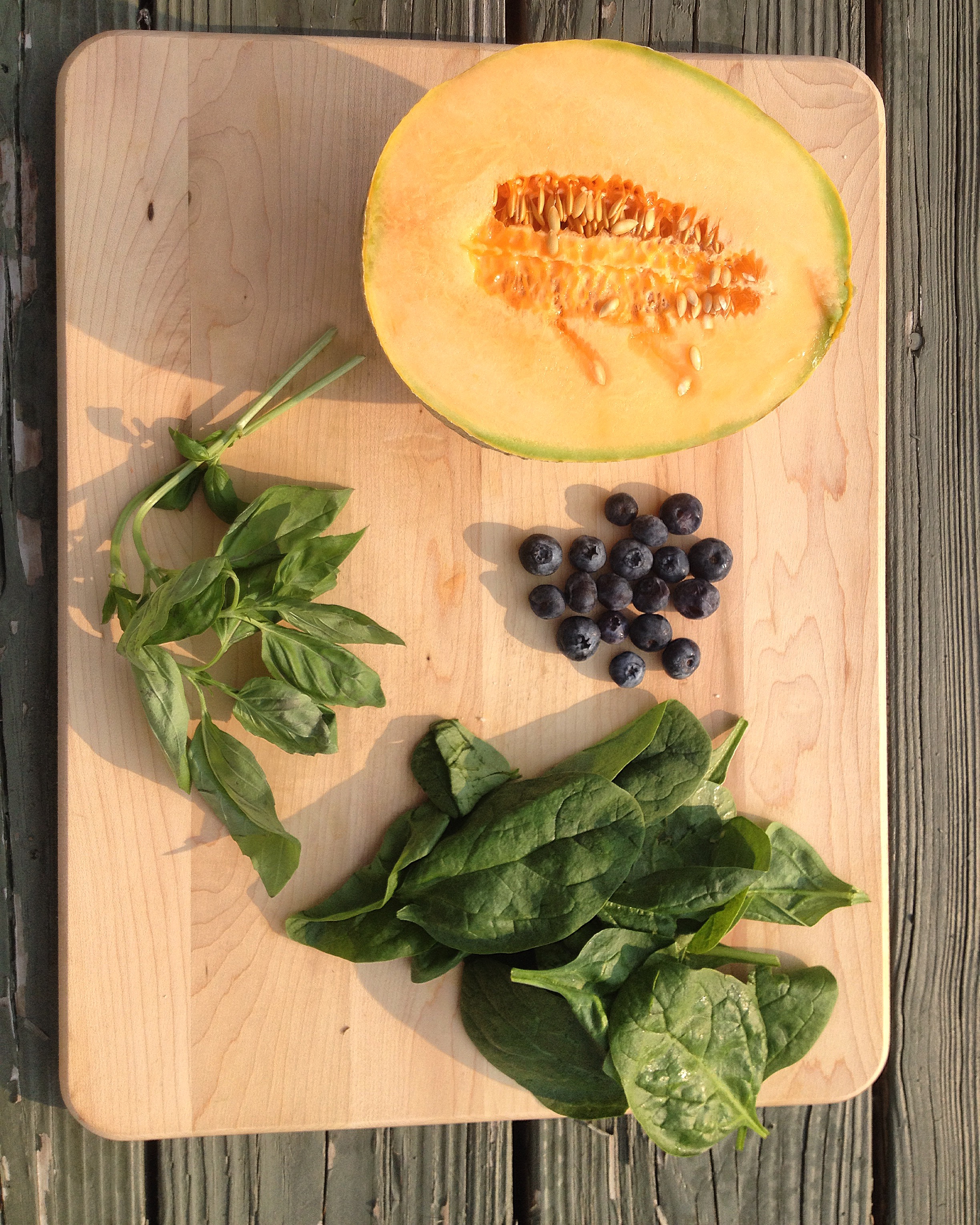 Displaying another image of cantaloupe salad with spinach and blueberries.